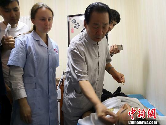 图为甘肃岐黄国医馆负责人何天有现场向国外中医爱好者教学“针灸”。　魏建军 摄