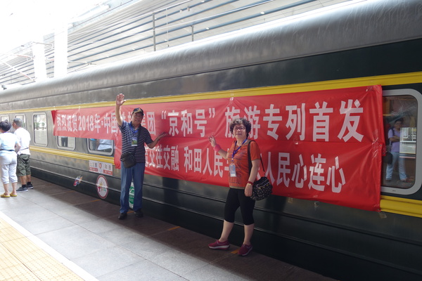 一对老夫妻在“京和号”车厢前留念