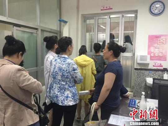 图为等候接种HPV疫苗的民众?！⊙爰ё柯?摄