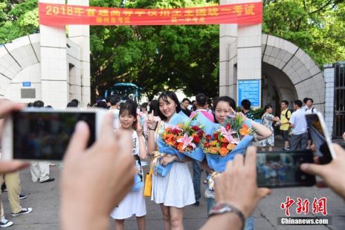 资料图：2018年高考结束，家长为刚刚走出考场的孩子拍照留念。 王以照 摄 