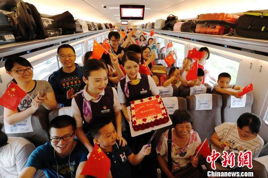 长编组“复兴号”动车组，列车员与旅客庆祝这一时刻。　殷立勤 摄