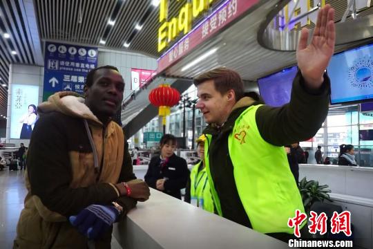 华南理工大学留学生参与2018年春运志愿者服务。资料图?！∈芊谜吖┩?摄
