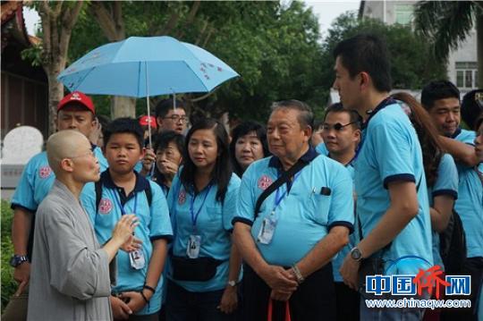 华裔青少年聆听龙华寺住持讲解?！±钛┯?摄