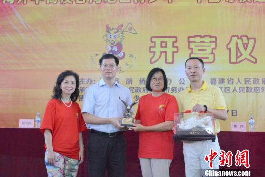 中国侨网7月9日，2018年海外华裔及台湾地区青少年“中国寻根之旅”夏令营——福建洛江营开营式上，主办方互赠纪念品?！∷锖纭∩? style=