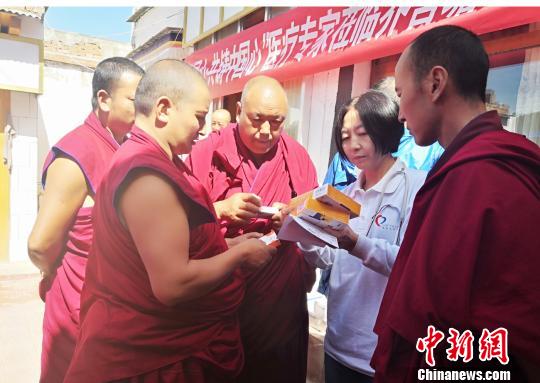 图为专家为僧人叮嘱服药注意事项。　南如卓玛 摄