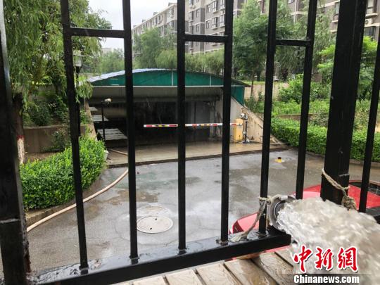 图为24日上午河北廊坊市某小区车库积水严重，物业加开临时管泵排水?！∷蚊籼?摄