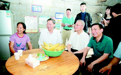 ▲调研组走进靖西市龙邦镇大莫村村民家中座谈交流，了解贫困户吕母千通过开办家庭酒坊，每月增收一千多元的脱贫经验。