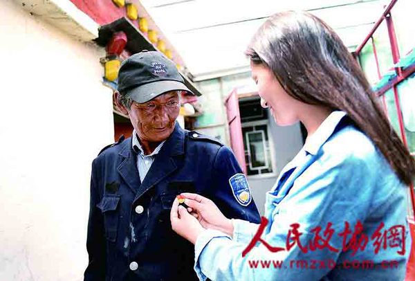 旺扎是多年的老党员，女儿阿旺卓玛为他佩戴党徽.jpg(1)