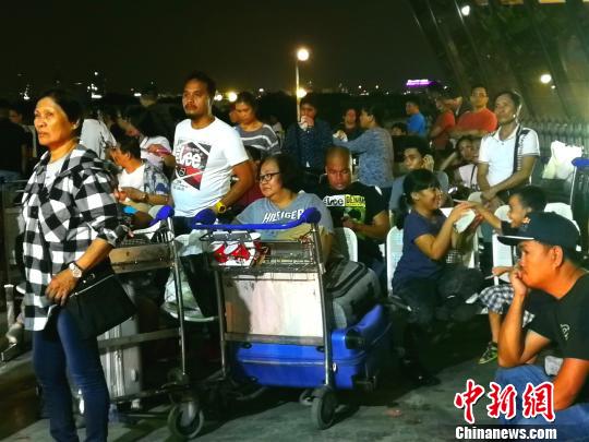 候机厅外不少滞留旅客将行李放在手推车上，靠着休息。　关向东 摄