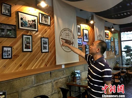 胡里山炮台管理处主任王勇介绍改造一新的瞭望台战地服务部内文化墙富装饰。杨伏山 摄