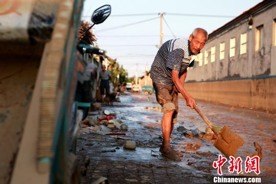 8月24日，洪水退去后潍坊寿光政府组织人员清理街道。潍坊市已启动《重大自然灾害卫生应急预案》最高级别响应。据统计，潍坊市已修复县乡路路基、路面79.14公里，?局部损毁桥涵11座；抢通县乡公路22条、143公里?！×籂?摄