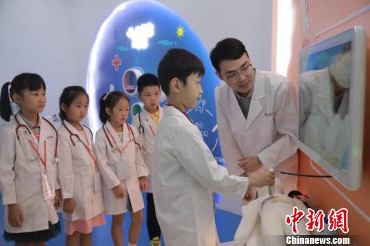 首批14名小体验者走进梦想医学院，穿上定制的白大褂，变身“见习小医生”?！≤缝?摄