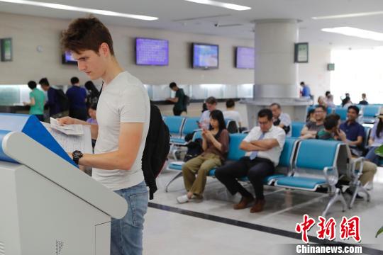 外籍人士正在上海市公安局出入境管理局内办理相关业务。　殷立勤 摄