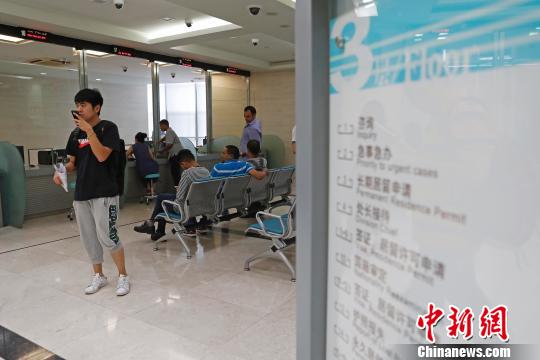 上海市公安局出入境管理局内，民众正在咨询和办理相关业务?！∫罅⑶?摄