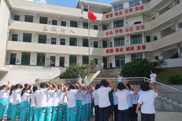 图2：开学第一天，岩山中学学生与岩山小学学生一起升国旗。