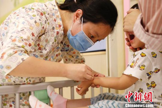 医护人员正在为孩子进行输液前的准备工作。　殷立勤　摄