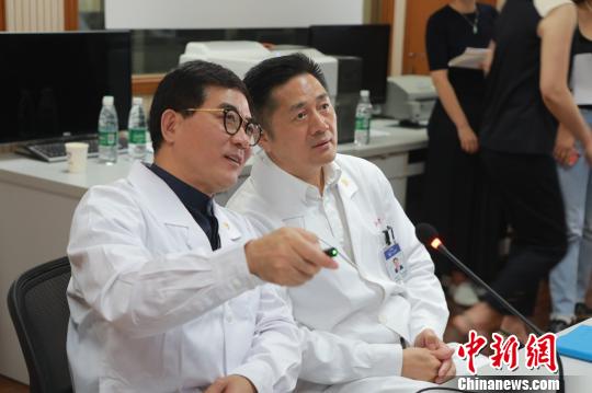 　院士们紧盯着屏幕，不时通过互联网远程视教系统，与主刀医师用简洁的专业术语进行沟通，不时提出指导意见。　芊烨 摄