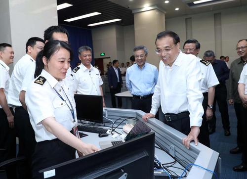 图为今年5月21日李克强考察海关总署时听取推进通关一体化便利化进展情况汇报。