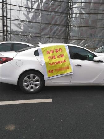 托管中介抢房大战，抢房广告甚至贴在车上。新京报记者 黄鑫宇 摄