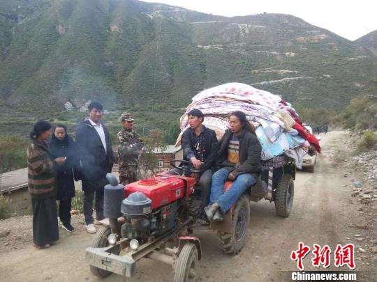 图为当地受灾村民转移家用物资?！〔际行抗┩?摄