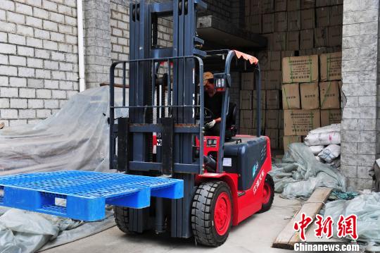 图为10月12日，西藏自治区民政厅救灾物资储备中心工人正在紧张地装载棉衣、棉被、棉褥、折叠床等救灾物资?！≌盼?摄