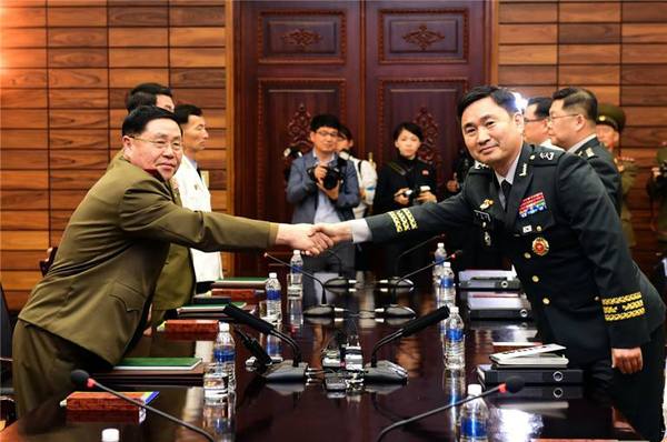 6月14日，在板门店朝方一侧“统一阁”，韩朝高级别军事会谈韩方代表团团长金度均（右）同朝方代表团团长安益山握手。新华社发（韩国国防部供图）
