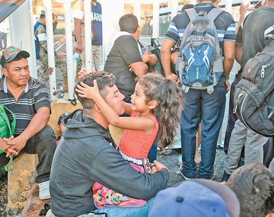 10月22日，在危地马拉特昆乌曼城，来自洪都拉斯并准备前往美国的移民等待进入墨西哥。新华社发