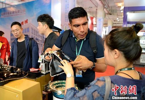 2018年4月19日，第二十届中国(晋江)国际鞋业暨第三届国际体育产业博览会在福建省晋江市开幕，引来了70个国家和地区的企业、采购商和专业买家。 图为国外客商“鞋博会”上“淘宝”。<a target='_blank' href='http://www.chinanews.com/'>中新社</a>记者 王东明 摄