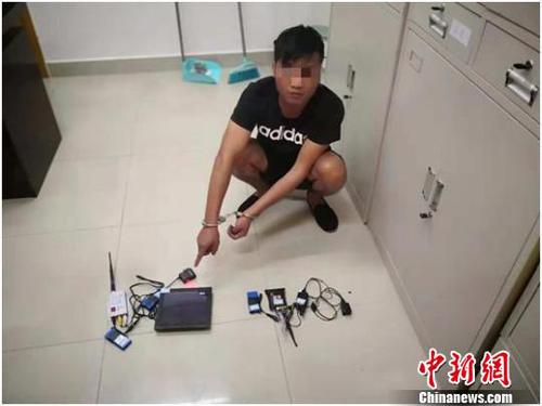 犯罪嫌疑人洗某达指认考试作弊工具 警方供图