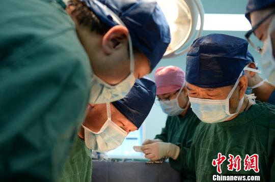 图为陈孝平与山西大医院医生实施手术?！『?摄