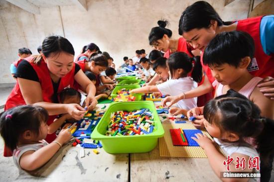 志愿者在与留守儿童一起搭积木、做游戏。 周亮 摄