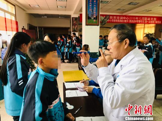 许海嘉在凉山筛查眼病患儿。　王鹏 摄