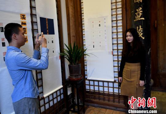 一名“90后”女大学生篆刻作者在自己创作的作品前留影?！〖钦吡蹩筛?摄