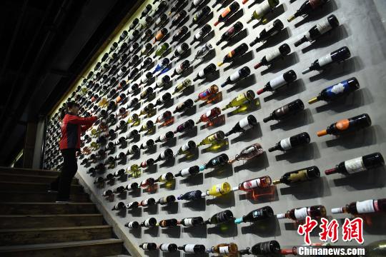 图为工作人员正在展厅内擦拭红酒瓶?！〕鲁?摄