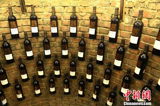 图为墙上挂了红酒?！〕鲁?摄