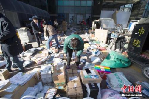 资料图：双十一期间物流工作人员正在分拣快递。 张云 摄