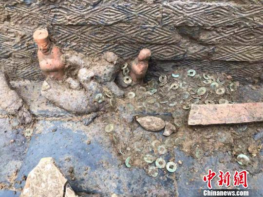 图为墓葬出土的陶俑和铜钱。(钟欣摄)