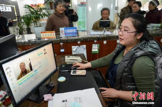 1月26日，安徽省合肥市庐阳区启动应用人脸识别系统开展养老金领取资格认证工作，该系统将为全区纳入社会化管理的4.4万企业退休人员进行“人脸建?！薄＞萘私?，“人脸建?！笔抢眉扑慊枷翊砑际?，从拍摄的人脸照片中提取人像特征点，建立数学模板。然后利用已建成的人脸特征模板与退休人员的人脸进行特征比对分析，来完成个人身份识别的过程。首次“人脸建?！背晒?，以后每年的养老金认证工作通过网络终端即可实现，解决了长期以来企业退休人员只能到指定地点或机构认证的繁琐做法，同时还可以有效遏制冒领养老金的现象。图为合肥市庐阳区水西门社区的工作人员在对企业退休人员进行“人脸建?！薄?lt;a target='_blank' href='http://www.chinanews.com/'>中新社</a>发 张娅子 摄