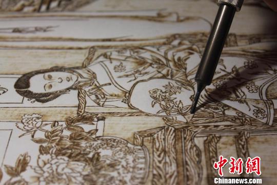 图为正在创作中的烙画作品?！⌒煅?摄