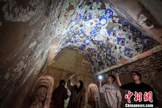 图为民众观赏1：1复原仿真洞窟?！〈蘖?摄