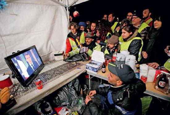 　12月10日，法国“黄背心”们观看法国总统马克龙的电视讲话。马克龙宣布法国进入“经济和社会的紧急状态”，并承诺从2019年起，将提高最低工资标准、不会轻易增税。图/视觉中国