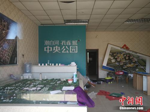 从燕郊一家已经关门的售楼处门外望进去，地上散落着废纸、条幅，沙盘上放着落灰的杀虫剂。<a target='_blank' href='http://www.chinanews.com/' >中新网</a>记者 邱宇 摄