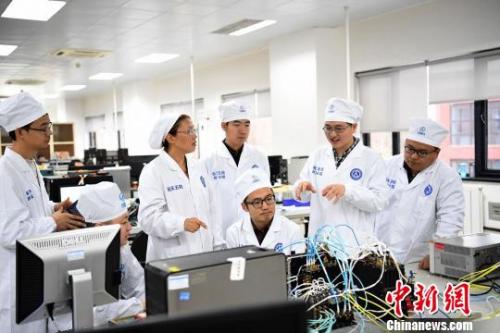 西安分院嫦娥四号探测器的研制人员正在讨论问题。　苏宏伟 摄