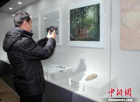 周口店遗址文物河北保定展出民众现场体验“钻木取火”