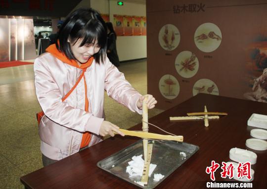 参观者现场体验“钻木取火”?！⌒烨擅?摄