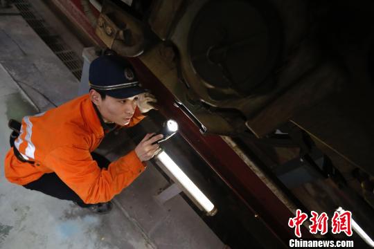 动车机械师正在检修动车车底部件?！《〔?摄