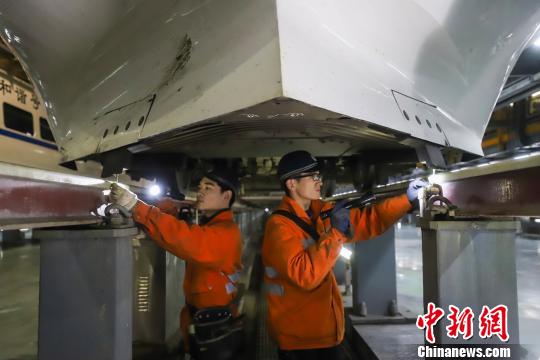 动车组机械师正在检查动车组底部组件。　肖尧 摄