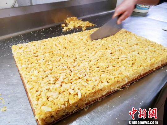 撒上白芝麻后按规格切块 李晓春 摄