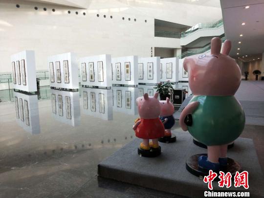 小猪佩奇“一家四口”站立在漫画展的对面，正远远观望着?！⊙钆迮?摄