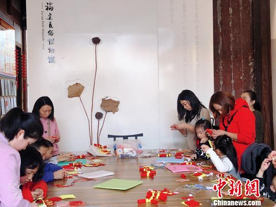 家长带着小朋友参与趣味手工体验活动?！∫肚镌?摄